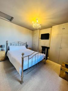 - une chambre avec un lit et un lustre dans l'établissement Simpsons Cottage - Grove Road Cottages, à Stratford-upon-Avon