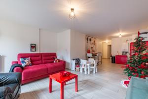 a living room with a red couch and a christmas tree at Bienvenue chez Mickey ! in Montévrain