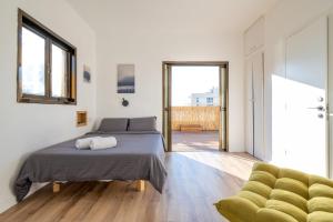 a bedroom with a bed and a green chair at Roof Top 3 Floors in Netanya