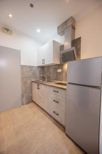 a kitchen with white cabinets and a refrigerator at House Kohili in Nea Vrasna