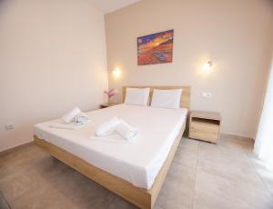 a bedroom with a large bed with white sheets at House Kohili in Nea Vrasna