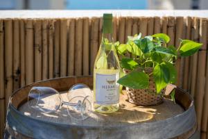 una bottiglia di vino e bicchieri su un tavolo con una pianta di Roof Top 3 Floors a Netanya