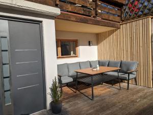 eine Terrasse mit einem Tisch, Stühlen und einer Tür in der Unterkunft Ferienwohnung Stoablick - barrierefrei mit Bergblick in Bad Goisern