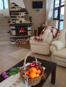 uma cesta de frutas numa mesa numa sala de estar com lareira em Cassiopea Villas em Pamporovo