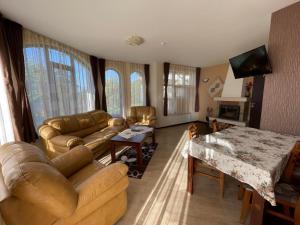 uma sala de estar com um sofá e uma mesa em Cassiopea Villas em Pamporovo