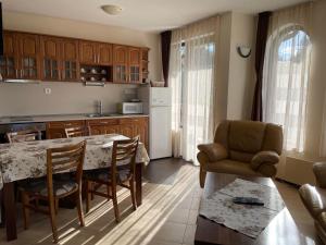 uma cozinha com mesa e cadeiras num quarto em Cassiopea Villas em Pamporovo