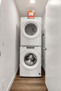 uma máquina de lavar e secar roupa num pequeno quarto em Luxurious Townhome with King Bed and Garage Parking em Calgary