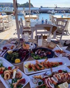 een tafel met veel borden eten erop bij Apartmani Vesna Paralia in Paralia Katerinis