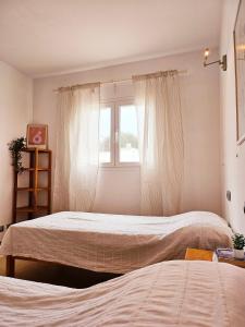 2 camas num quarto com uma janela em Casa Voramar em Cala d´Or