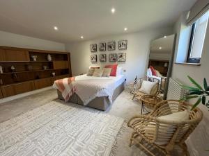 a bedroom with a bed and a chair at Beachcliff Rooms & Apartments in Cardiff