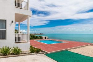 a house with a swimming pool and the ocean at Breathtaking Turtle Tail Drive Oceanfront Villa in Providenciales