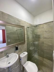 a bathroom with a shower and a toilet and a sink at Encanto Apartahotel in Santa Marta