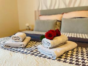 a group of towels on a bed with a rose on them at Piękny zielony zakątek na Kaszubach - agroturystyka z jacuzzi in Strzepcz