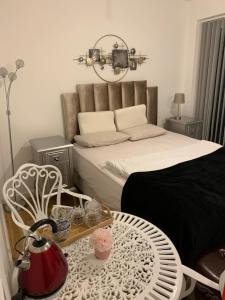 a bedroom with a bed and a table and chairs at Countryside Luxury House Harlow in Harlow