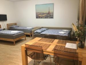 Sala de estar con 2 camas y mesa en Apartments in Residence Garden Towers, en Praga