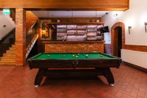 a billiard room with a pool table and stairs at Hotel Pod Figurą in Ogrodzieniec