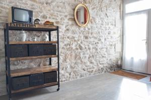une télévision sur une étagère dans une pièce dans l'établissement Appartement Les Cyprès de l’Île, à Avignon