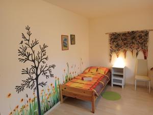 a bedroom with a bed with a tree mural on the wall at Gasthof Zemlinski Family Room in Payerbach