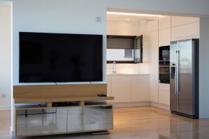 una grande TV a schermo piatto su un supporto in cucina di Seafront Luxury Suite Idassa by Belmont Realty a Zara (Zadar)