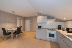 a kitchen with white appliances and a table with chairs at Residenz Dünenstrasse in Binz