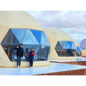 dos personas parados frente a edificios abovedados en European luxury camp en Disah