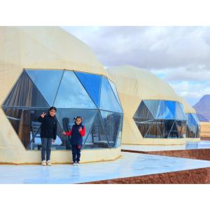 two people standing in front of domed buildings at European luxury camp in Disah