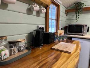 a kitchen with a counter with a wooden counter top at Panteinion Hall- The Cabin in Fairbourne
