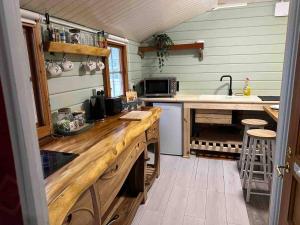 a kitchen with a wooden counter and a sink at Panteinion Hall- The Cabin in Fairbourne