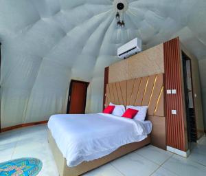 a bedroom with a large white bed with red pillows at European luxury camp in Disah