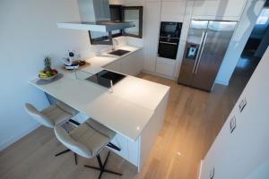 una cucina con bancone bianco e frigorifero di Seafront Luxury Suite Idassa by Belmont Realty a Zara (Zadar) Altre 37 foto