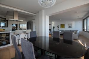 una sala da pranzo e un soggiorno con tavolo e sedie neri di Seafront Luxury Suite Idassa by Belmont Realty a Zara (Zadar)
