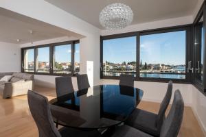 una sala da pranzo con tavolo e sedie in vetro di Seafront Luxury Suite Idassa by Belmont Realty a Zara (Zadar)