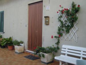 カステルフィダルドにあるLe Fornaciの花の壁掛けの隣のベンチ