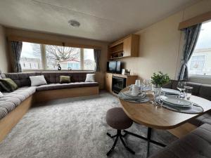 sala de estar con mesa y sofá en Lovely 8 Berth Caravan At Highfield Grange In Essex Ref 26213o, en Clacton-on-Sea
