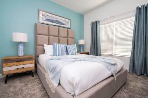 een slaapkamer met een groot bed met blauwe muren bij Marvelous 4Bd with Pool at Storey Lake Resort 2601 in Kissimmee