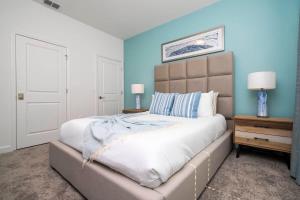 een slaapkamer met een groot bed met blauwe muren bij Marvelous 4Bd with Pool at Storey Lake Resort 2601 in Kissimmee +31 foto's