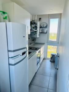 a kitchen with a white refrigerator and a window at Frente al Rio in Zárate