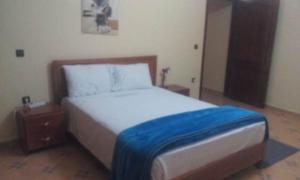 Un dormitorio con una cama con una manta azul. en RESIDENCE HOTELIERE CANALINA, en Tarfaya
