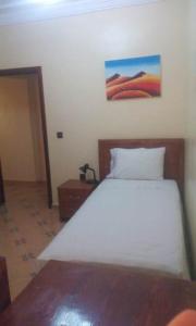 um quarto com uma cama e um quadro na parede em RESIDENCE HOTELIERE CANALINA em Villa Bens