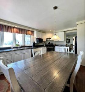 a kitchen with a large wooden table and chairs at Rosedale Cottage@Baksam lake in Fenelon Falls