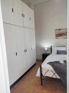 D&G City Centre Home في مدينة هيراكيلون: غرفة نوم بيضاء مع سرير ودواليب بيضاء