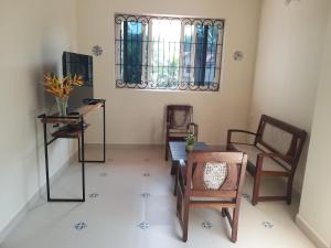 sala de estar con sillas, escritorio y ventana en Homestay- Casa Gracias - R - 01, en Carmona