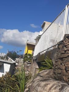 Ein weißer Zaun und einige Felsen und Pflanzen in der Unterkunft KIT DA BERE in São Thomé das Letras