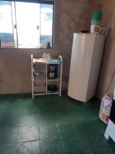 eine Küche mit einem weißen Kühlschrank und grünem Boden in der Unterkunft KIT DA BERE in São Thomé das Letras