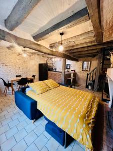 ein Schlafzimmer mit einem großen Bett in einer Ziegelwand in der Unterkunft Le Cottage des Chalands in Saint-Georges-sur-Cher