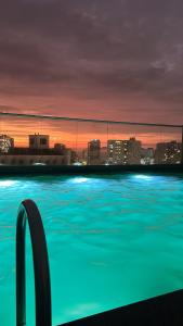 a swimming pool with a city skyline at night at Apartamento en Barranco in Lima