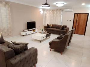 a living room with two couches and a tv at Cozy home in East Legon Hills in Accra