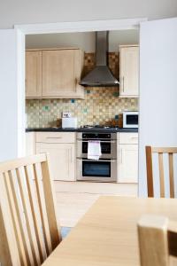 ロンドンにあるMadison Hill - Bedford Hill 1 - One bedroom flatのキッチン(コンロ、テーブル、椅子付)
