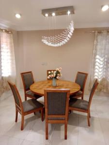 a dining room with a wooden table and chairs at Cozy home in East Legon Hills in Accra