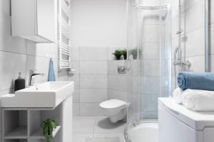 a white bathroom with a toilet and a sink at Krowodrza Apartment's in Krakow